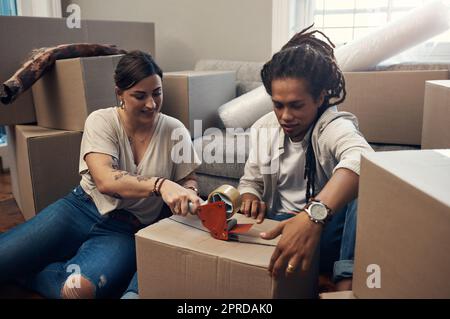 Celui-ci est prêt à partir. Un jeune couple qui porte des boîtes à la maison. Banque D'Images