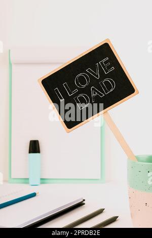 Texte d'écriture J'aime papa. Concept d'affaires bons sentiments au sujet de mon père affection affectueuse bonheur petit Blackboard avec message important dans la coupe sur le bureau avec le presse-papiers. Banque D'Images