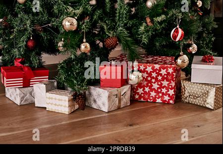 Les cadeaux sont prêts à être ouverts. Un bouquet de cadeaux placés sous un arbre de Noël prêt à être ouvert le matin. Banque D'Images