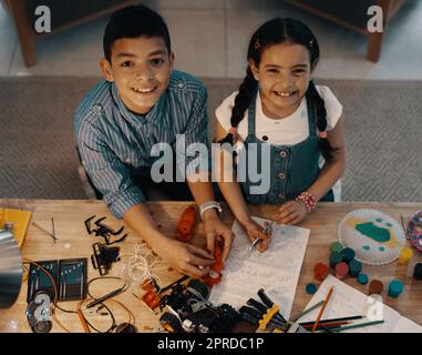 Smart est le nouveau cool gars. Portrait grand angle de deux adorables jeunes frères et sœurs construisant un jouet robotique ensemble à la maison. Banque D'Images