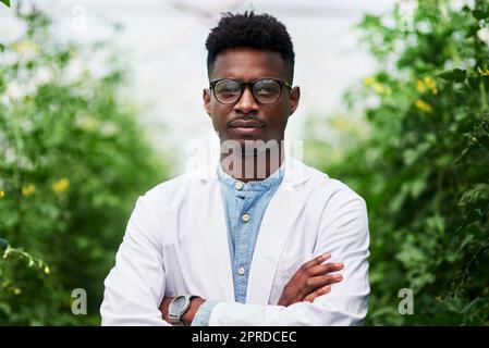 Sauver notre terre merveilleuse sera toujours un problème sérieux. Portrait d'un beau jeune botaniste posant avec ses bras repliés à l'extérieur dans la nature. Banque D'Images