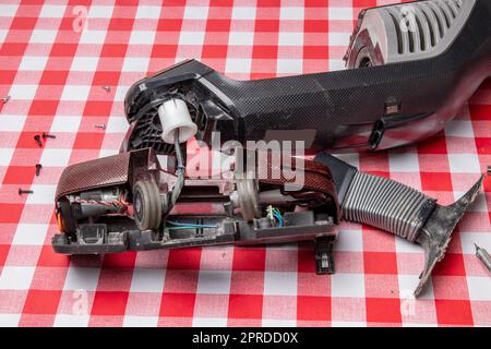 Réparation d'appareils ménagers. Un technicien professionnel répare un aspirateur. Service à la clientèle des appareils ménagers. Batterie hoover. Réparation par un spécialiste sur site. Banque D'Images