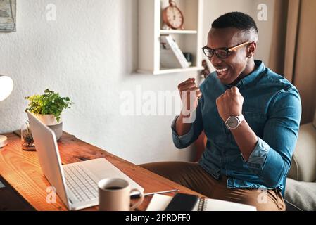 Homme excité sur un ordinateur à la maison se sentant heureux, confiant et fier de gagner un jeu en ligne de casino Web. Homme souriant qui profite d'une victoire numérique à l'intérieur. Guy célébrant le succès et s'amusant à l'intérieur Banque D'Images