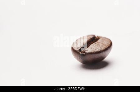 Un seul grain suffit. Photo studio d'un grain de café sur fond blanc. Banque D'Images