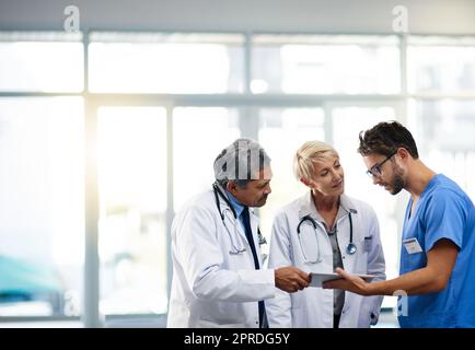 Professionnel de la santé, équipe et travailleurs tenant une tablette, parlant et résolvant un problème en ligne tout en étant au travail dans un hôpital. Des experts de la santé discutent, planifient et font de la recherche Banque D'Images