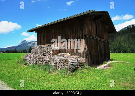 Hangar en bois sur un pré sous un ciel bleu Banque D'Images