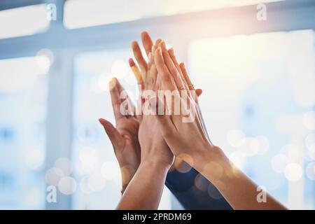 Le travail d'équipe fait le travail de rêve. Un groupe d'hommes d'affaires méconnus qui se soulèvent les bras et se joignent à eux dans l'unité au travail. Banque D'Images