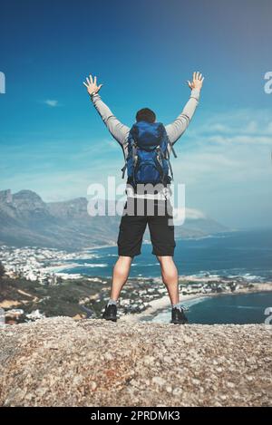 Il n'y a pas de meilleur sentiment que cela. Vue arrière d'un homme debout au sommet d'une montagne. Banque D'Images