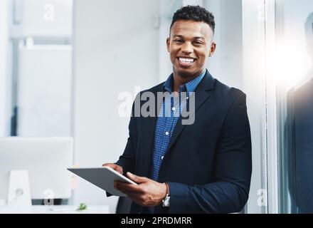 L'époque est aussi productive que l'autre sans mon appareil le plus puissant. Portrait d'un jeune homme d'affaires utilisant une tablette numérique dans un bureau. Banque D'Images