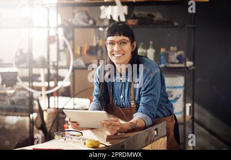 La messagerie instantanée est la meilleure en matière de créativité. Portrait rogné d'une jeune femme attrayante travaillant sur son ordinateur portable tout en se tenant dans son atelier créatif. Banque D'Images