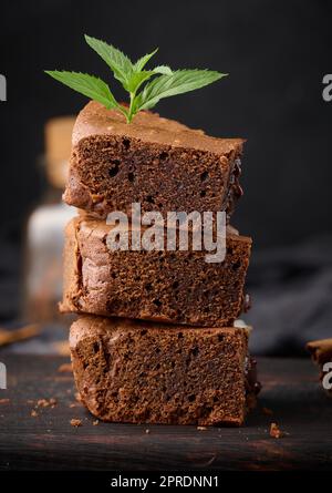 Morceaux de tarte au chocolat au brownie sur table noire, délicieux dessert Banque D'Images