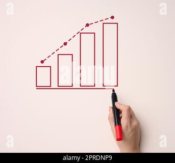 Graphique avec des indicateurs de croissance et une main femelle avec un marqueur sur fond beige. Banque D'Images