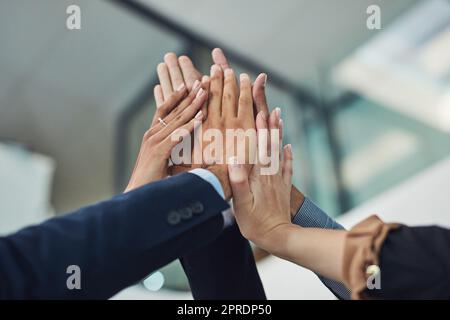 Mettez-les en valeur pour réussir. Gros plan d'un groupe d'hommes d'affaires méconnus qui tiennent la main pendant une journée pour un cinq au bureau. Banque D'Images