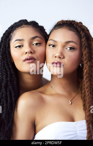 Naturellement beau. Photo de studio de deux jeunes femmes qui se posent sur un fond gris. Banque D'Images