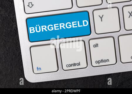 Clavier avec le mot allemand Bürgergeld ( engl. Citizen Money) isolé sur fond sombre. Nouveau système d'aide financière en Allemagne. Concept de soutien social. Banque D'Images
