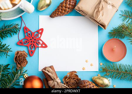 Composition de Noël ou du nouvel an, modèle. Décorations, boîte, cannelle, cônes, branches de sapin et d'épicéa, tasse de café, sur fond de papier bleu. À Banque D'Images