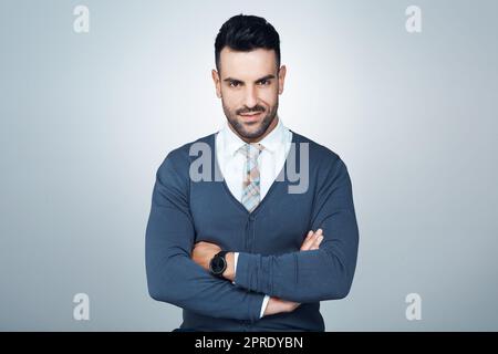 Il se démarque comme un changement de la donne. Portrait studio d'un beau jeune homme d'affaires se posant sur un fond gris. Banque D'Images