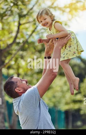 Donnez-leur des ailes et laissez-les voler. Un père liant avec sa petite fille à l'extérieur. Banque D'Images