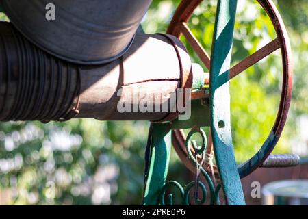 Un puits avec un seau dans un village européen. Jour ensoleillé. Seau en métal pour un puits d'eau. Détail d'un puits avec un seau en étain dans la campagne. Décorer le jardin avec des articles vintage. Banque D'Images