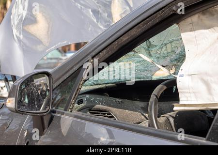 A tourné la voiture pendant la guerre en Ukraine. Une voiture après un accident avec une vitre arrière cassée. L'épave de l'intérieur d'une voiture moderne après un accident, une vue détaillée de la voiture endommagée. Banque D'Images