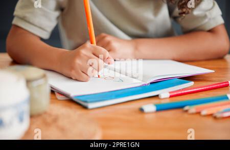 Enfant coloriant, dessin et faisant l'activité d'art dans le livre dans le salon de maison tout en s'amusant, appréciant et se sentant ludique. Gros plan des petites, petites et jeunes filles créatives exprimant avec de la couleur Banque D'Images