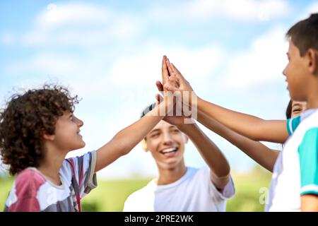 Vous pouvez toujours compter sur les frères et sœurs pour vous garder motivé. Un groupe de frères et sœurs heureux se donnant un haut cinq dehors. Banque D'Images