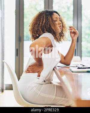 Elle ressent tout ce travail difficile. Une jeune femme d'affaires attirante éprouve une gêne corporelle dans son bureau à la maison. Banque D'Images