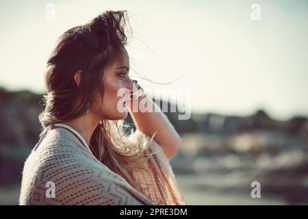 L'océan, où elle rassemble ses pensées. Une jeune femme attrayante passant une journée à la plage. Banque D'Images