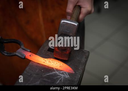 les mains de l'homme fabriquent un couteau en acier Banque D'Images