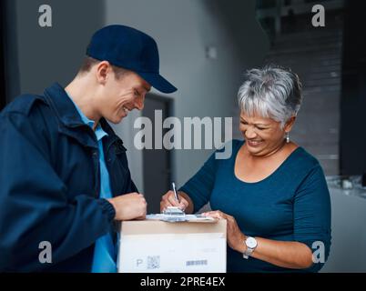 Un autre client satisfait bénéficiant de notre service de livraison. Un beau jeune homme livrant un paquet à un client. Banque D'Images