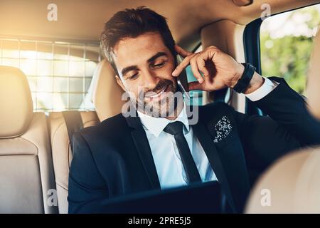 HES entend de bonnes nouvelles sur le chemin de son bureau. Un beau jeune homme d'affaires d'entreprise sur un appel pendant les trajets. Banque D'Images