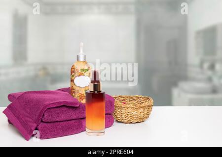 Une belle composition de soins spa sur la table avec serviettes, huile de massage, crème et un panier sur salle de bain floue. Espace pour le montage de l'affichage du produit. Banque D'Images