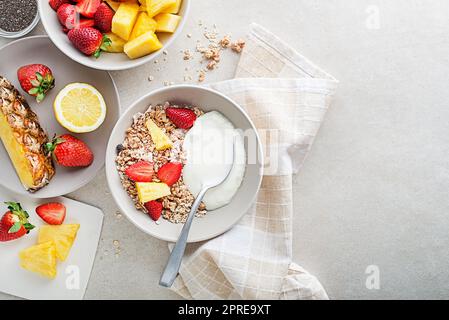 Un bol de granola sec servi avec des fruits frais et du yaourt. Plaque à flocons d'avoine. Alimentation saine, alimentation. Vue de dessus. Banque D'Images