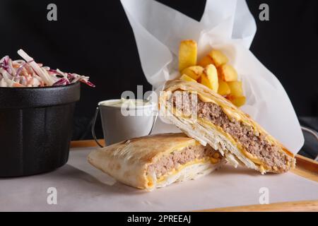 Côtelette de bœuf au fromage roulé dans le pita avec des pommes de terre frites et du chou rouge Banque D'Images