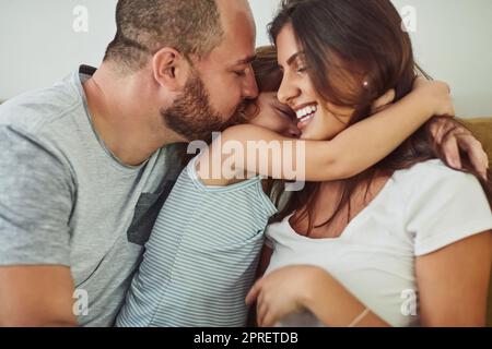 Trésor de ces moments. Une mère et un père se liant à leur adorable jeune fille à la maison. Banque D'Images