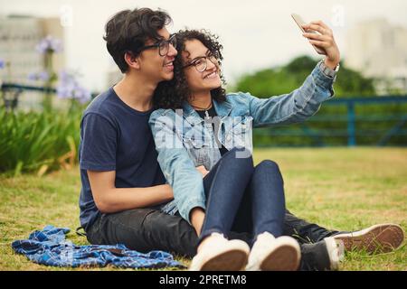 Doux selfies pour commémorer ce jour. Un couple adolescent prenant un selfie à l'extérieur. Banque D'Images