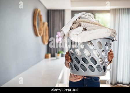 C'est ma chose la moins préférée à faire. Une femme portant un panier à linge plein de lavage à la maison. Banque D'Images