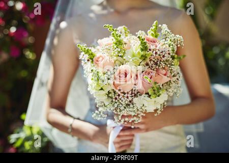 Qui va attraper cela je me demande. Une femme méconnaissable tenant un bouquet de fleurs à un mariage. Banque D'Images