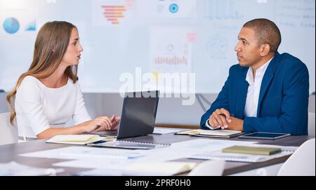 Collaboration, travail d'équipe et équipe de planification de professionnels du marketing et de la publicité des médias sociaux qui discutent lors d'une réunion stratégique. Un homme et une femme travaillant sur un bureau, un poste de travail ou un bureau désordonné Banque D'Images