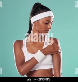 Blessures sportives, douleurs au bras et joueur de tennis souffrant de douleurs musculaires après un match de balle sur le terrain. Femme douloureuse, blessée et gêné après un entraînement sportif ou match sur fond de studio. Banque D'Images