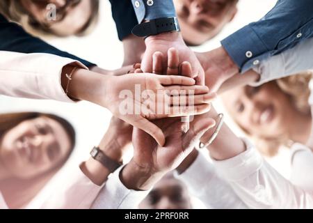 Étaient toujours là pour se motiver les uns les autres. Portrait d'un groupe d'hommes d'affaires en petit angle, mettant les mains ensemble dans un caucus. Banque D'Images