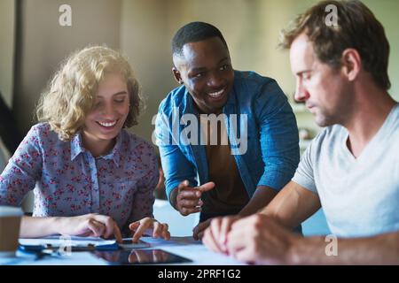 Naissance d'une application mobile. Un groupe diversifié d'hommes et de femmes d'affaires travaillant sur un projet dans un bureau moderne. Banque D'Images