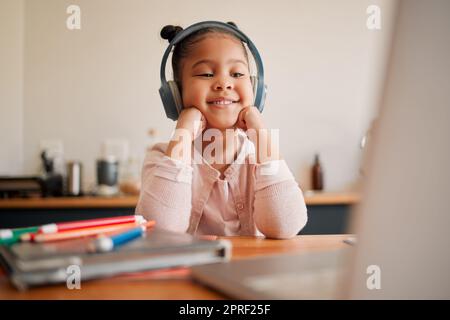 Apprentissage à distance, éducation et leçon en ligne avec une fille portant un casque et une webcam pour ordinateur portable. Kindergaten ou école primaire Etudiant avec vidéo virtuelle classe Internet avec un enseignant à la maison Banque D'Images