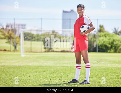 Sports, femme athlète et joueur de football entraînement au stade terrain de football avec but post. Exercice déterminé, le joueur de fitness se prépare pour le prochain match de tournoi debout sur le terrain Banque D'Images