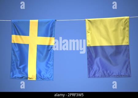 Deux drapeaux suédois bleus, jaunes, fanions, bannières ou drapeaux suspendus sur une corde. Le ciel bleu est visible en arrière-plan. Ukraine. Banque D'Images