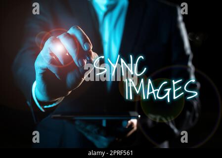 Symbole de texte indiquant les images synchronisées. Présentation de l'entreprise rendre les photos identiques sur tous les appareils accessibles n'importe où main avec un stylo pointant des informations importantes avec d'autres tablettes de maintien Banque D'Images