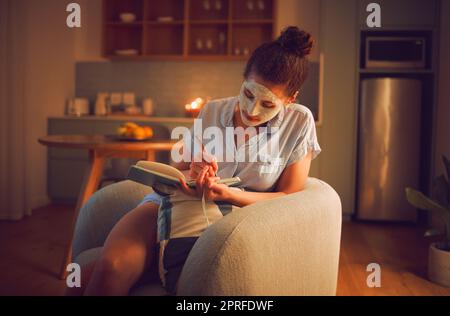 Soin de soi, toilettage et écriture créative par une femme prenant des notes dans le journal tout en se donnant un visage. Idées de planification de femme détendue pour un roman dans un journal, appréciant le temps libre et un passe-temps apaisant Banque D'Images