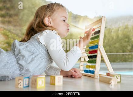 Éducation, abacus et fille apprenant les mathématiques avec un outil de couleur tout en comptant sur le plancher. Les jeunes enfants ou les étudiants jouent aux mathématiques ou calculent le jeu avec Banque D'Images