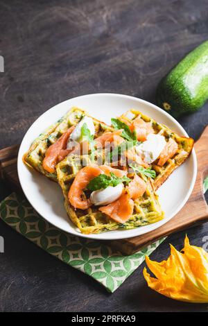 Gaufres belges avec courgettes et légumes verts, fromage cottage et saumon salé. Banque D'Images