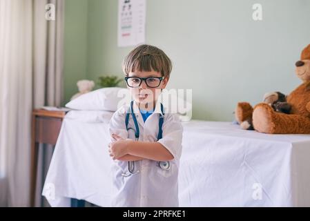 Permettez à votre enfant de développer ses propres intérêts. Un adorable petit garçon habillé comme un médecin. Banque D'Images